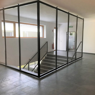Immobilien Referenzen 512 Treppenhaus mit Treppenabgang. Der Treppenabgang ist mit einer luftigen Stahlkonstruktion umgeben.