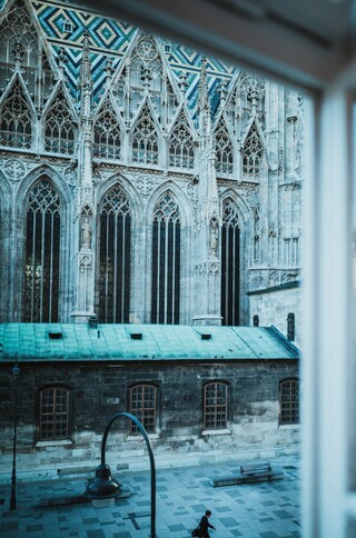 Blick durch ein Fenster auf einen Sakralbau.