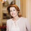 Mag. Alexandra Winkler (Hotel Sacher) steht lächelnd in einer historischen Räumlichkeit.