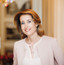 Mag. Alexandra Winkler (Hotel Sacher) steht lächelnd in einer historischen Räumlichkeit.