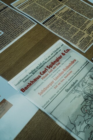 Historische Zeitungsberichte liegen auf einem Tisch.