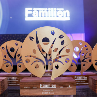 Trophäen mit der Aufschrift "Österreichs beste Familienunternehmen" sind auf einem Tisch gelagert.