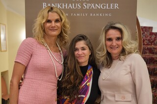 Die Dirigentin und Komponistin Nazanin Aghakhani steht zwischen 2 Frauen vor dem Bankhaus Spängler Bannerdisplay.