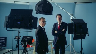 Dr. Nils Kottke und ein Mann stehen vor Aufnahmegeräten. Beide Männer schauen lächelnd in die Kamera.