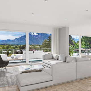 Großer Wohnraum mit hellem Parkettboden. Im vorderen Bereich ist ein helles Sofa platziert im hinteren Teil des Raumes eine Essgruppe. Großzügige Fensterfronten geben den Blick in die Natur frei.