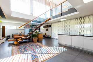 Moderner, heller Wohnbereich - eine Treppe mit Glasverkleidung ist ersichtlich