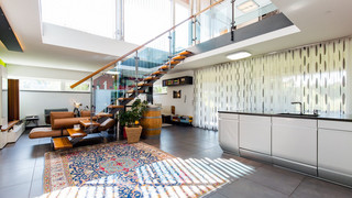 Moderner, heller Wohnbereich - eine Treppe mit Glasverkleidung ist ersichtlich