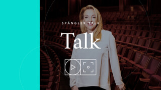 Eine Bildaufnahme einer Dame in den leeren Zuschauerrängen eines Theaters mit der Aufschrift "Spängler Talk".