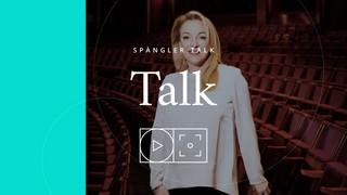 Eine Bildaufnahme einer Dame in den leeren Zuschauerrängen eines Theaters mit der Aufschrift "Spängler Talk".