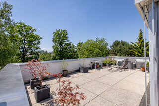 Ein Balkon mit Steinbodenfliesen und einer Liege