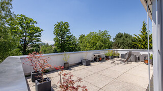 Ein Balkon mit Steinbodenfliesen und einer Liege