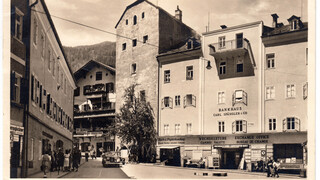 Ein historisches Schwarz-Weiß-Foto zeigt eine Häuserreihe einer Stadt.