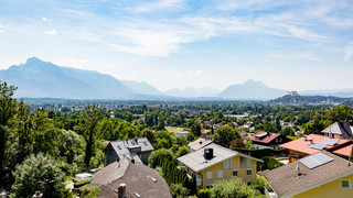 Aussicht Richtung Berge, Bäume und ein Wohngebiet