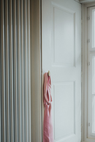 Zwei rosa Krawatten hängen auf einem weißen Fensterladen.