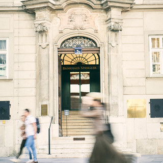 Äußere Eingangsfassade des Bankhaus Spängler am Stephansplatz in Wien. Im Vordergrund spaziert eine Frau vorbei.