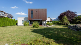 Modernes Haus mit Holzverkleidung von außen, umgeben von einem grünen Garten