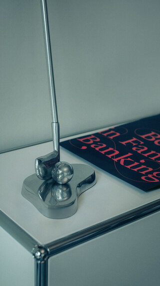 Detailaufnahme eines Tischaccessoires neben einer Publikation mit dem Schriftzug „Best in Family Banking“.