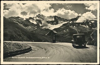 Ein altes schwarz-weiß-Foto zeigt ein Auto auf einer Straße mit Blick auf einen Gletscher.