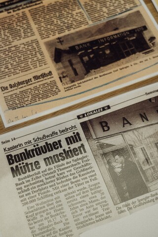 Historische Zeitungsartikel liegen auf einem Tisch.