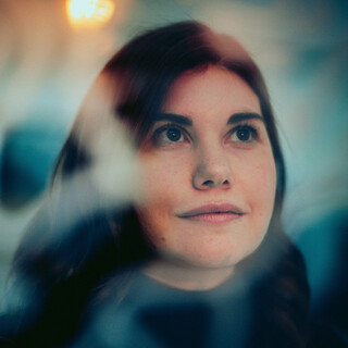 Eine lächelnde Dame blickt in die Ferne.