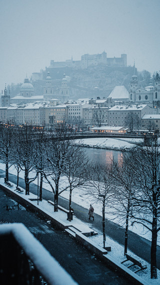 Ausblick auf die winterliche Skyline von Salzburg mit Salzach, Altstadt und Burg.