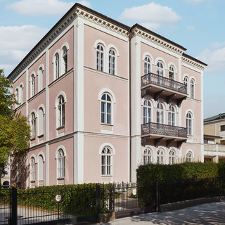 Bankgebäude des Bankhaus Spängler in der Schwarzstraße 17 in 5020 Salzburg von außen. Das Gebäude hat 3 Stockwerke, die Fassade ist hellrosa, 2 Balkone und viele Fenster sind ersichtlich. 