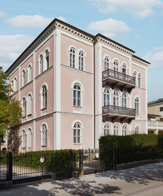 Bankgebäude des Bankhaus Spängler in der Schwarzstraße 17 in 5020 Salzburg von außen. Das Gebäude hat 3 Stockwerke, die Fassade ist hellrosa, 2 Balkone und viele Fenster sind ersichtlich. 