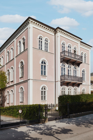 Bankgebäude des Bankhaus Spängler in der Schwarzstraße 17 in 5020 Salzburg von außen. Das Gebäude hat 3 Stockwerke, die Fassade ist hellrosa, 2 Balkone und viele Fenster sind ersichtlich. 