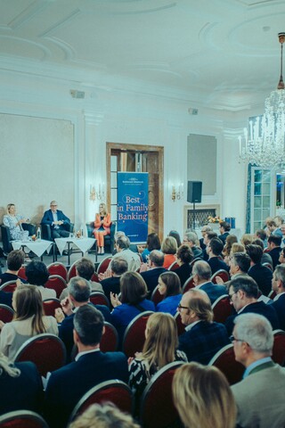 Publikum lauscht einer Podiumsdiskussion in einem historischen Saal.